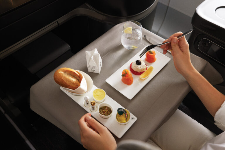 Bandeja de refeição servida na classe econômica da Turkish Airlines, mostrando um prato quente, salada, sobremesa e pão.