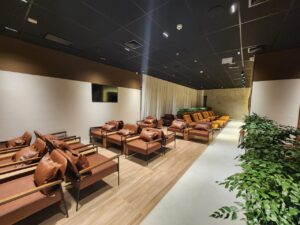 Área de assentos do lounge AMBAAR Club em Viracopos, com poltronas modernas e decoração inspirada em Campinas.
