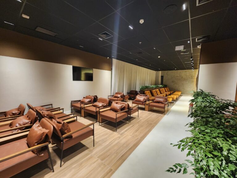 Área de assentos do lounge AMBAAR Club em Viracopos, com poltronas modernas e decoração inspirada em Campinas.